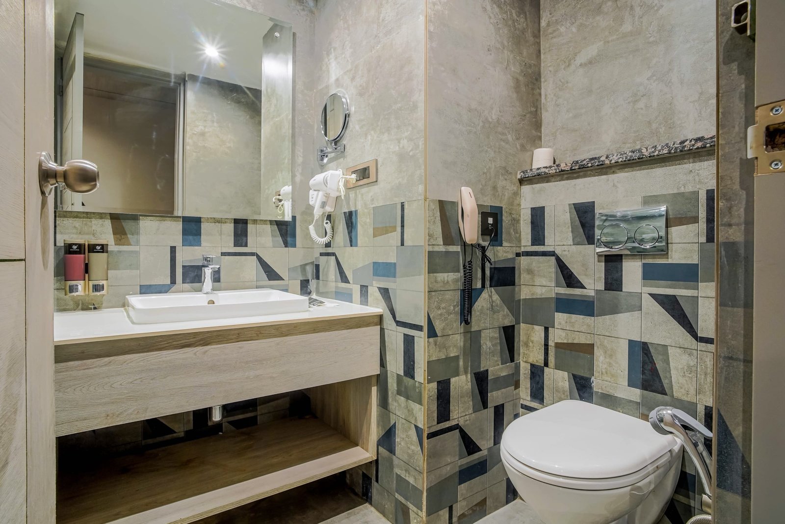 Bathroom with geometric tiling and a stone vanity