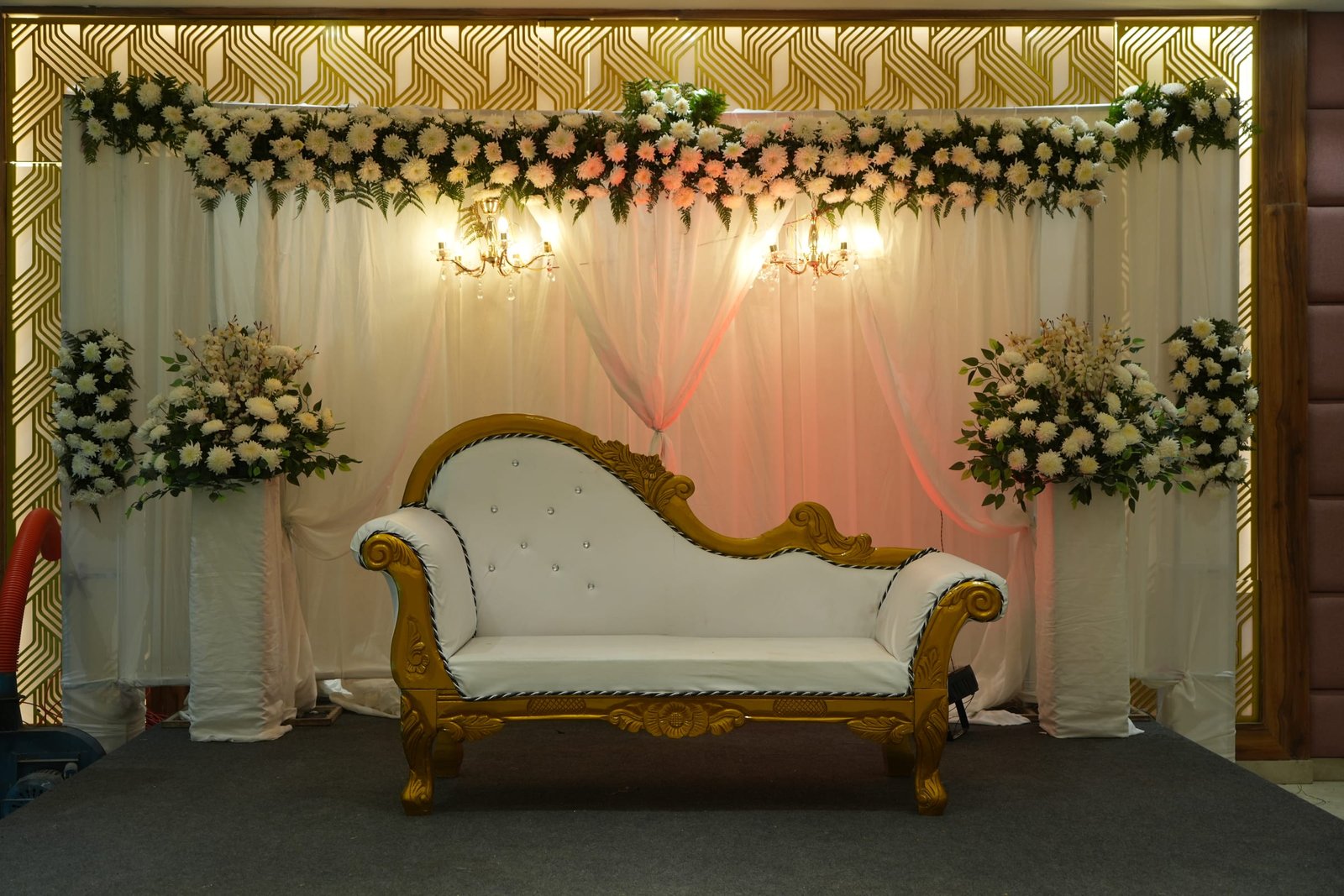 Wedding stage dressed in florals with a gilded settee