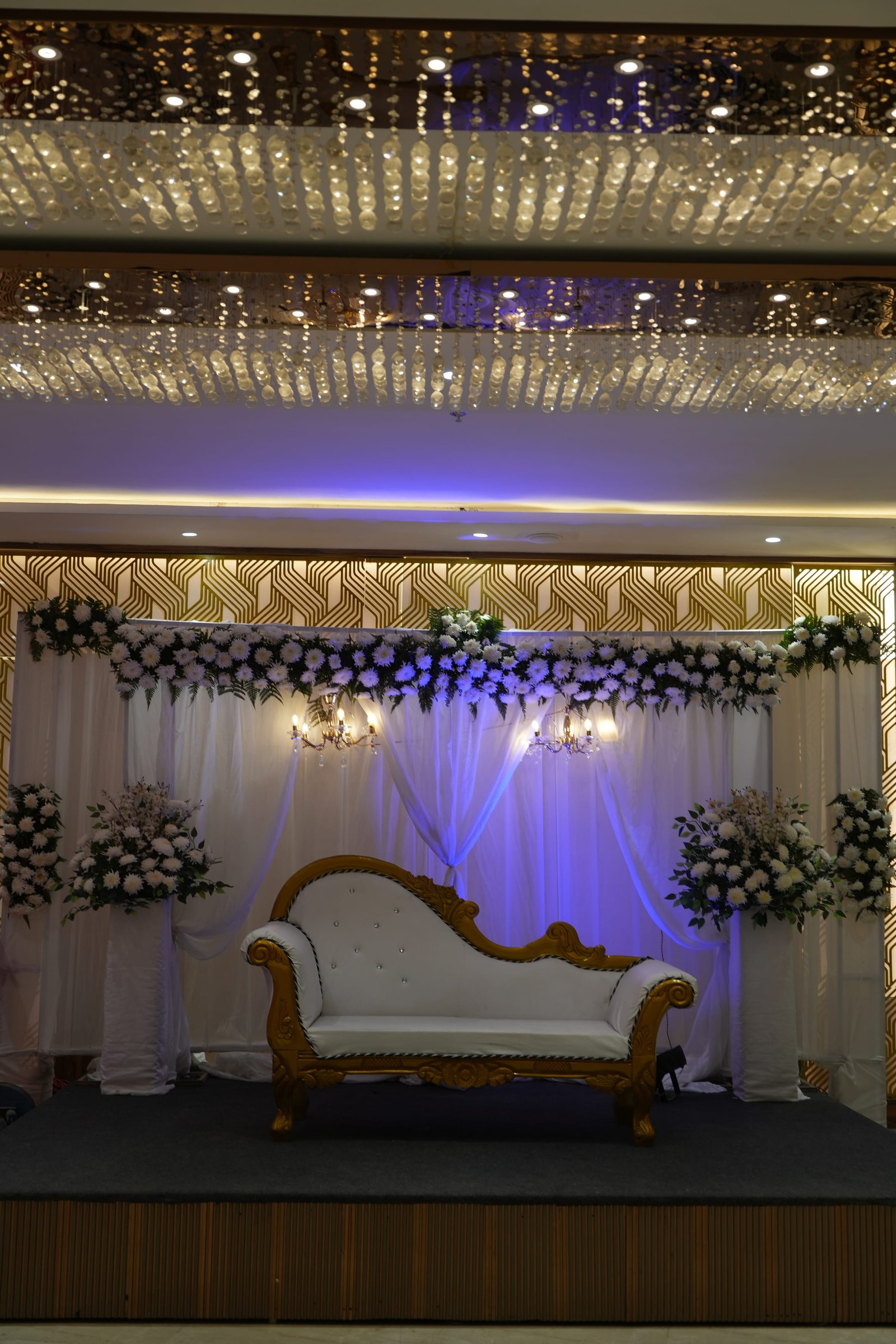 Floral arch and drapery behind the reception stage