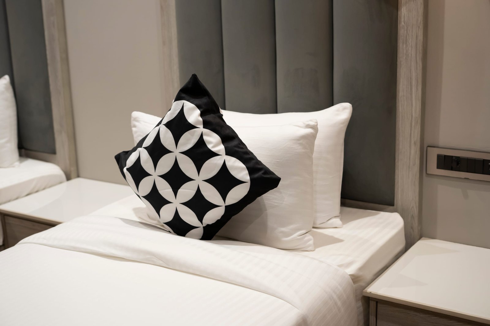 Pillows and a patterned cushion on a made bed