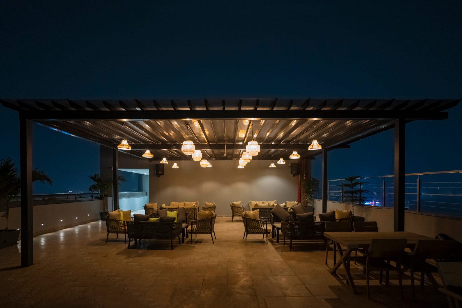 The rooftop terrace under its timber pergola at blue hour