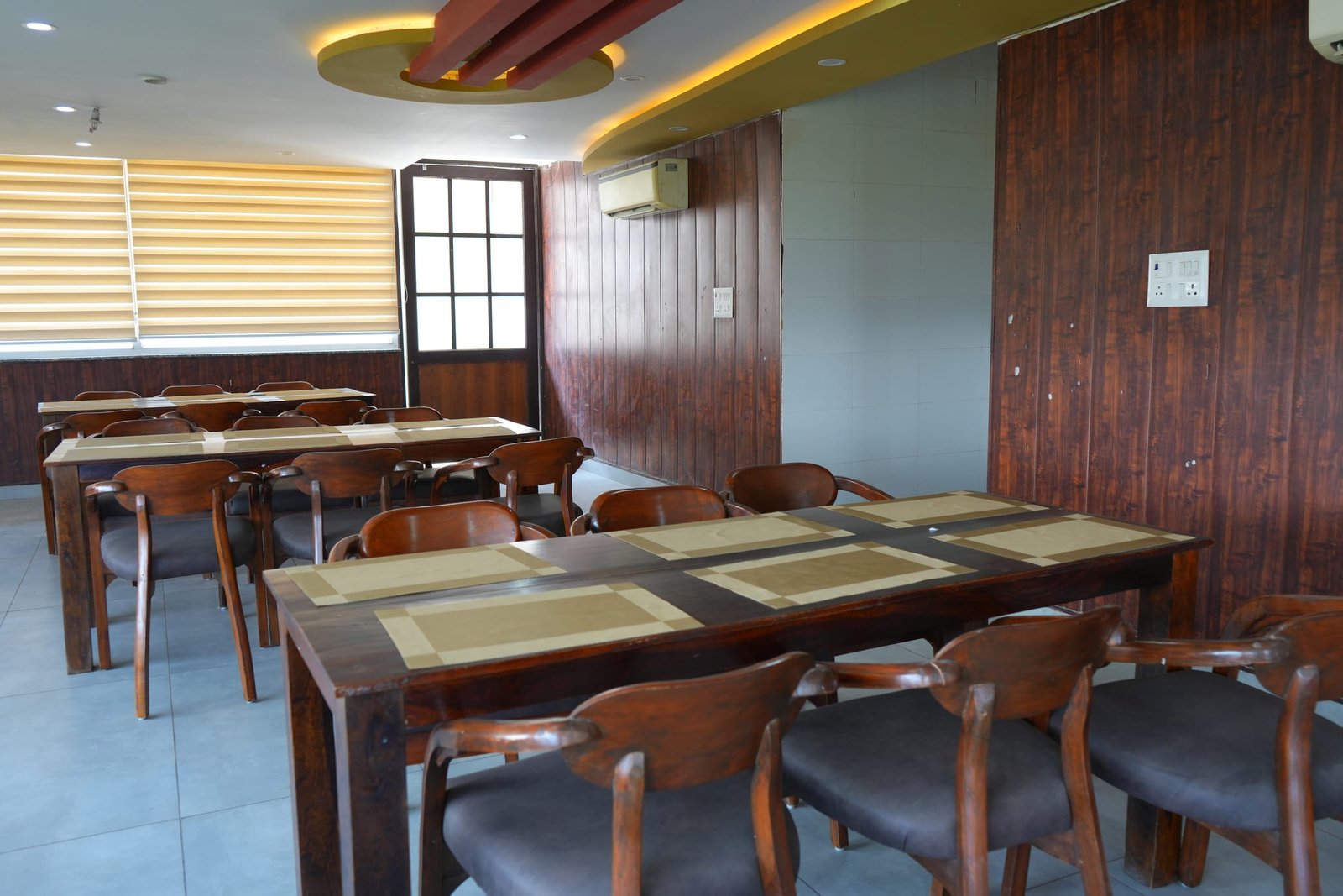 The length of the dining room, tables laid for a sitting