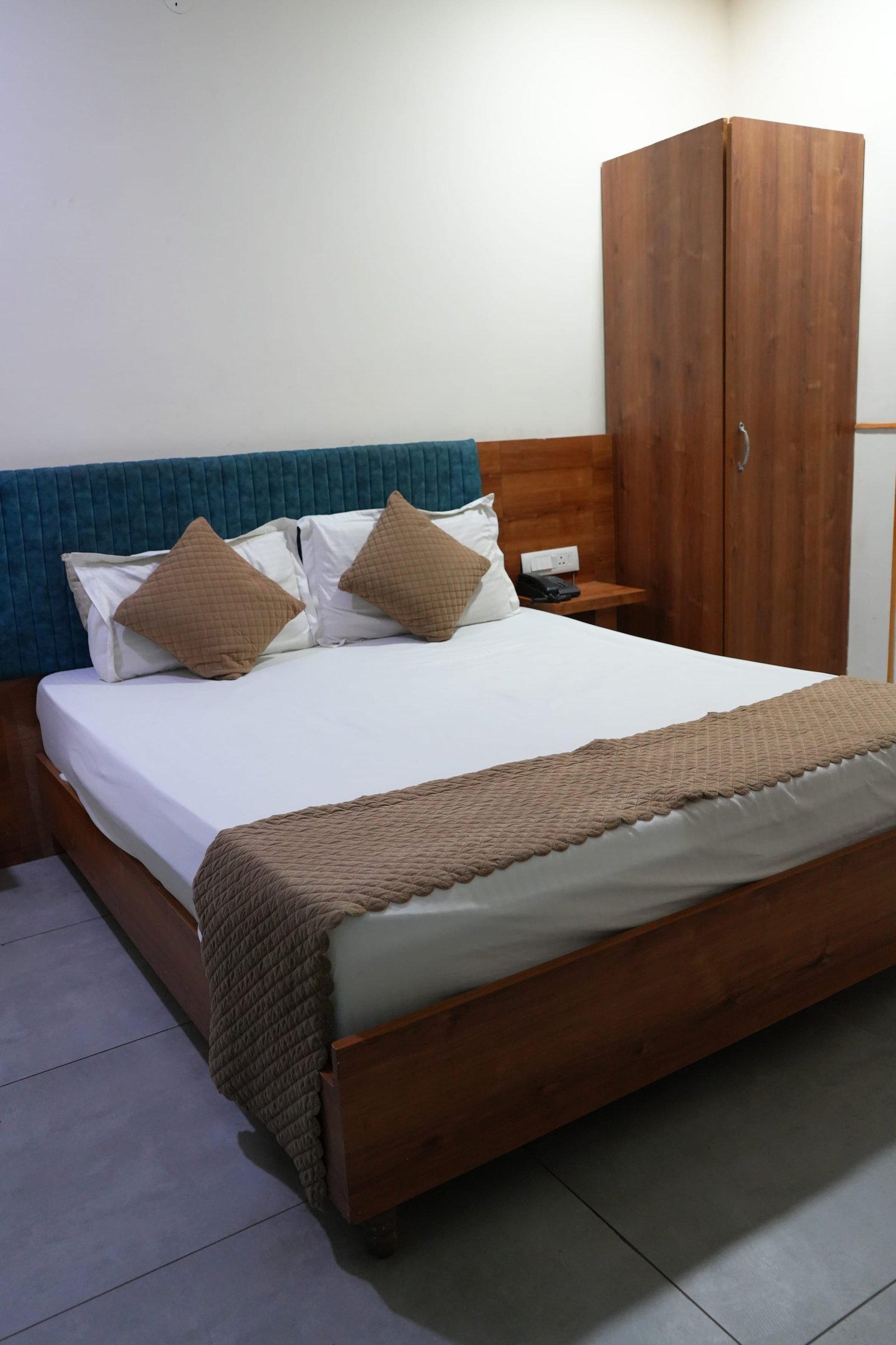 A made bed with a runner and cushions