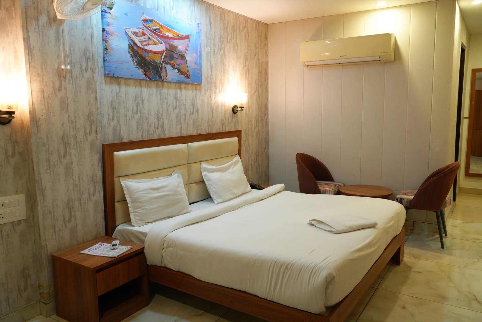 Double room with the air conditioner above the bedside chair