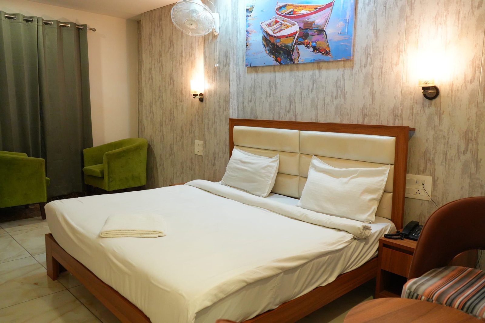 Twin beds pushed together under a painting of moored boats